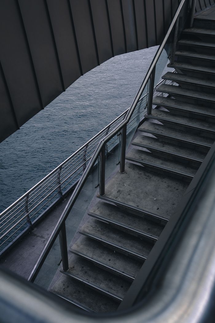 Services A contemporary staircase with metal railings overlooking a body of water.