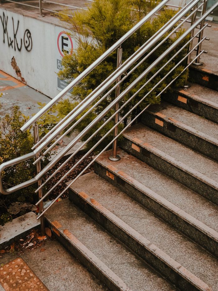 Services High angle view of an urban staircase with metal handrails and greenery.